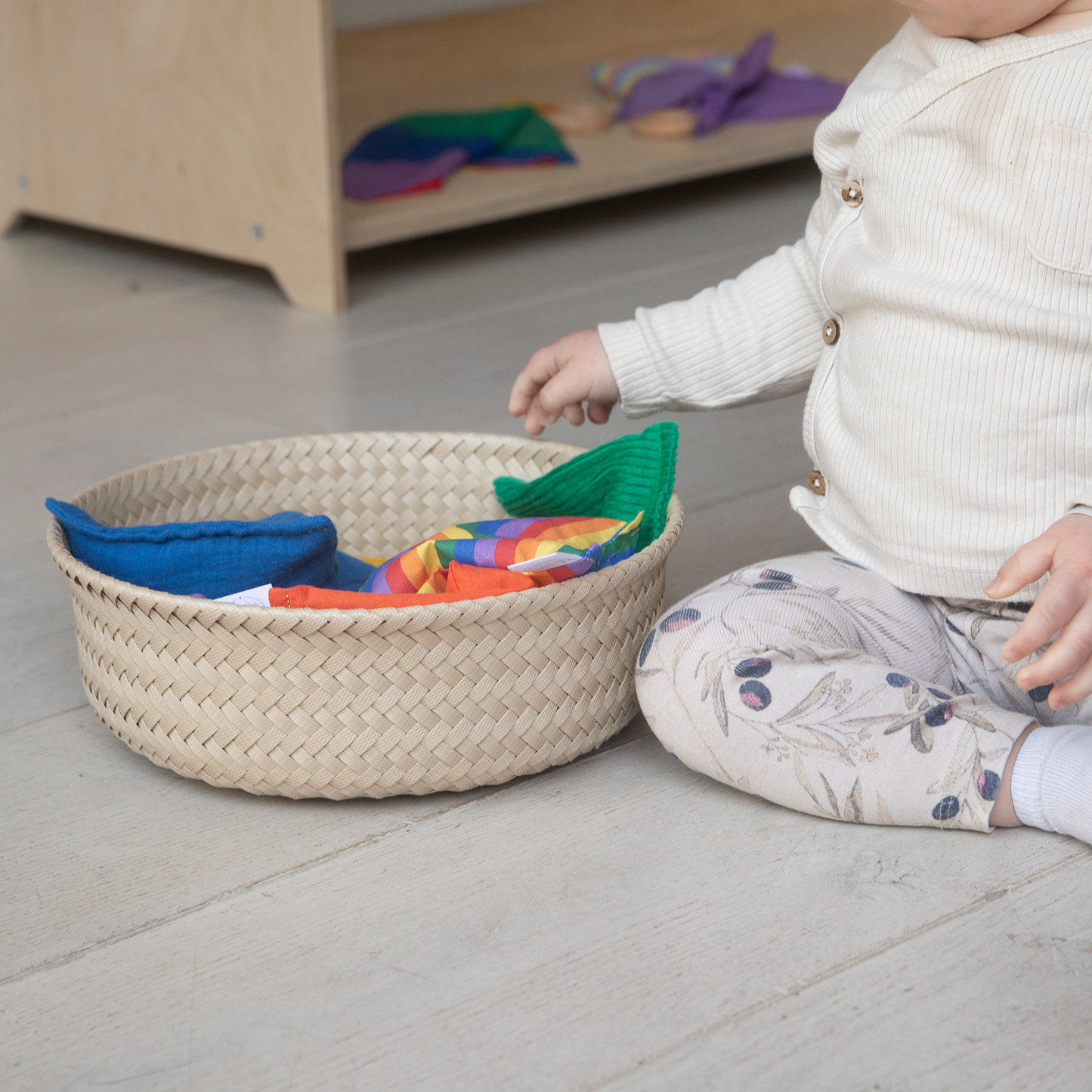 Baby speelt met regenboog pittenzakjes