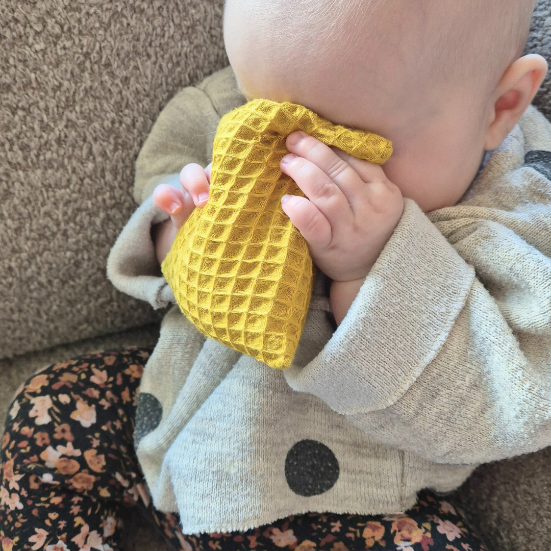 baby speelt met sensorisch pittenzakje