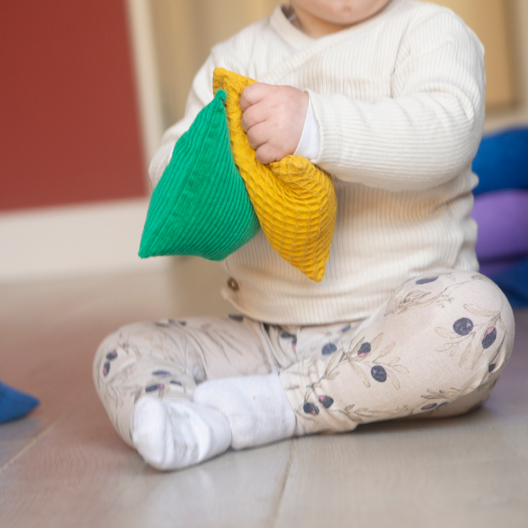 baby met sensorische pittenzakjes, sensomotorisch speelgoed