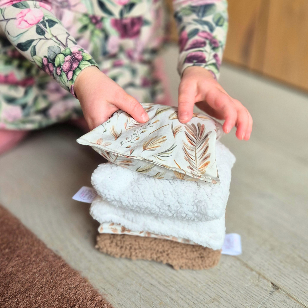 kind stapelt sensorische pittenzakjes in zachte kleuren